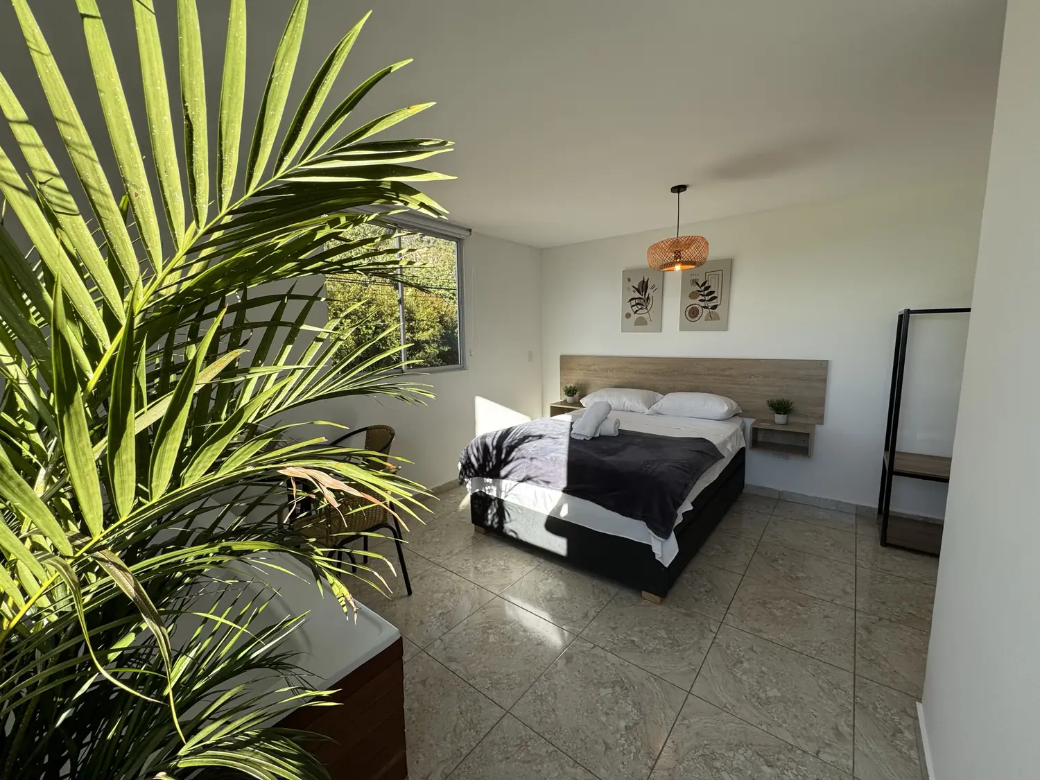 Caoba room with a double bed, plants and a window onto the greenery.