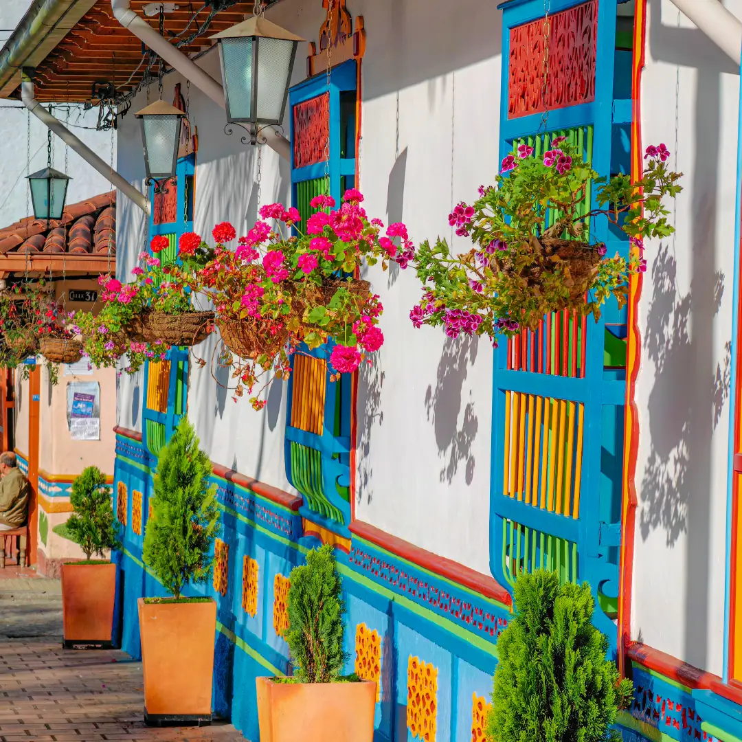 A street in Guatapé with coloured façades, flowers and painted zócalos.