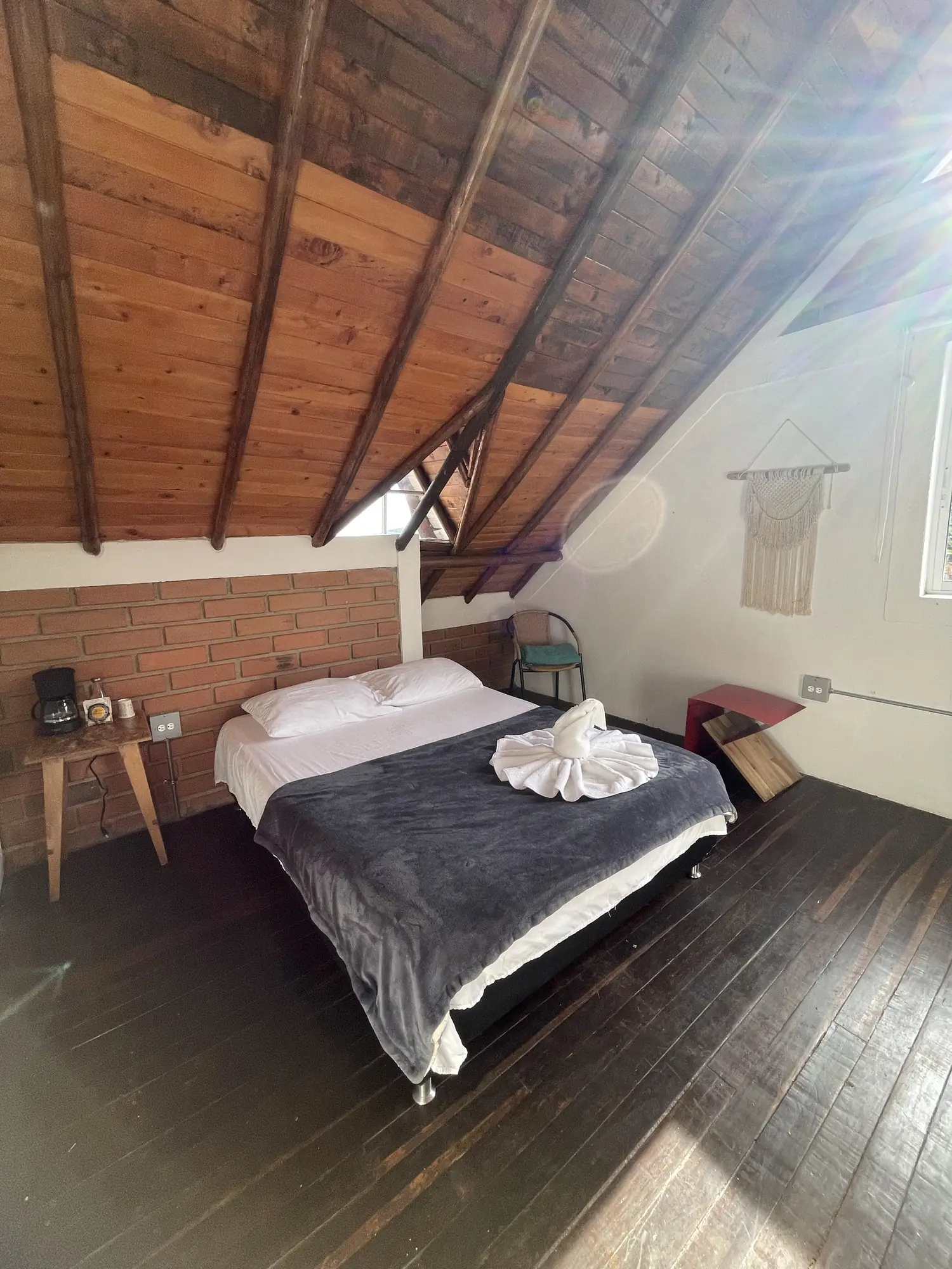 Laurel room with a pitched wooden roof and a double bed.