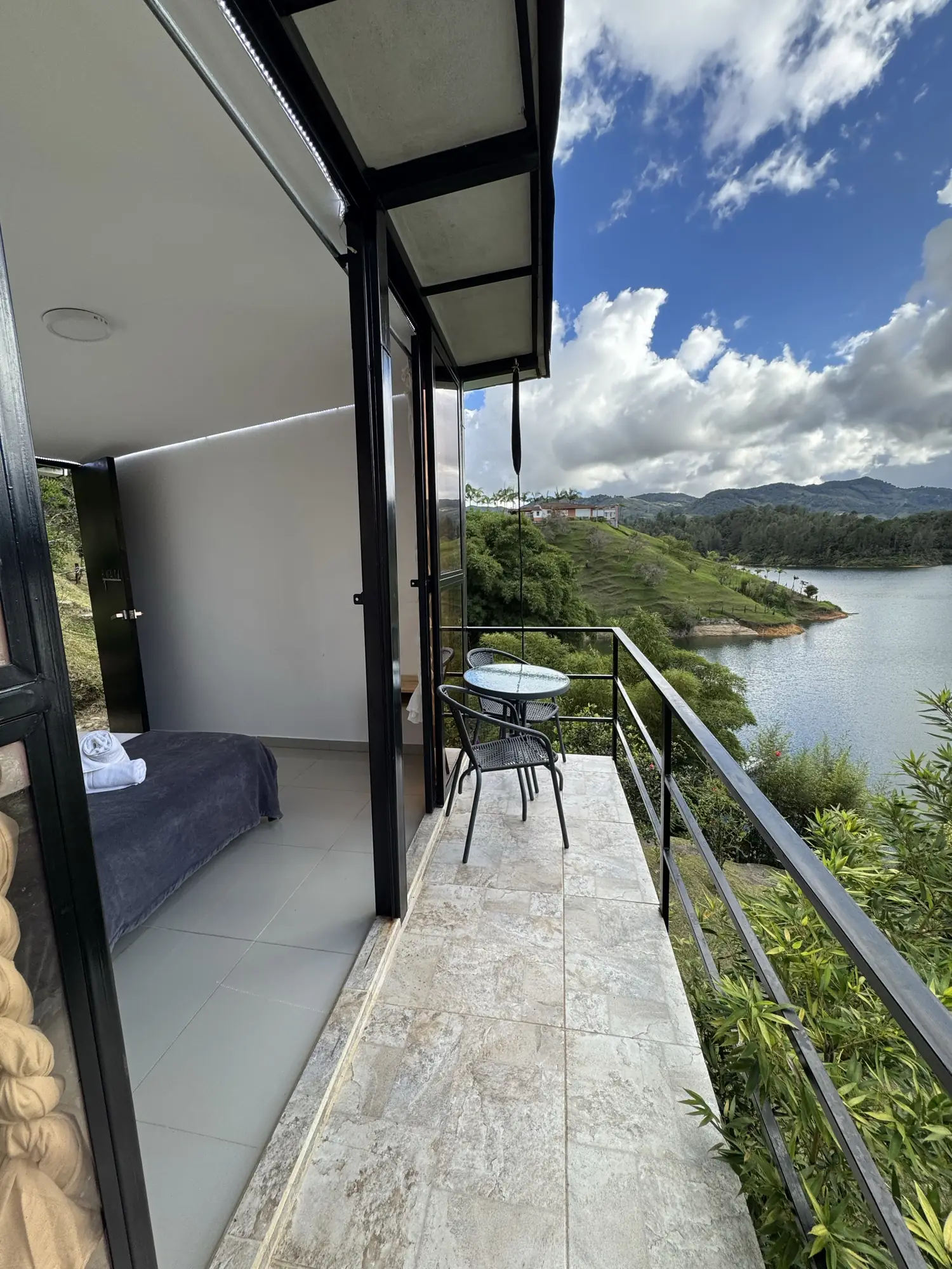 Cabaña Roble Deluxe with floor-to-ceiling windows and a deck balcony over the reservoir.