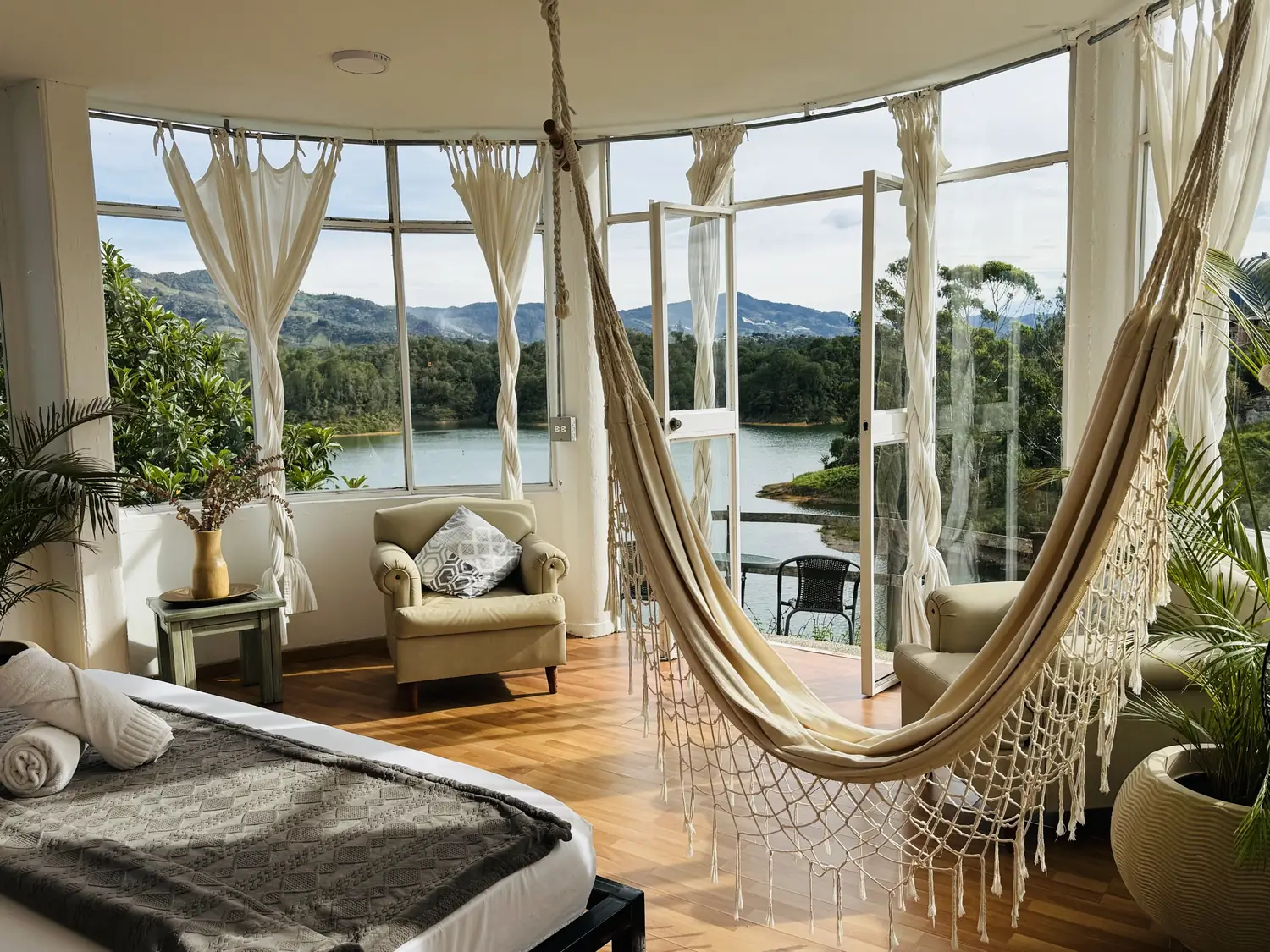Suite La Madriguera with a King bed, hammock and curved windows over the reservoir.